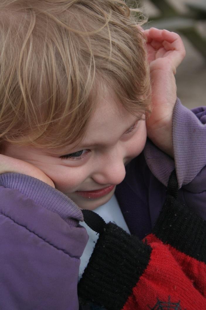 Niña tapándose los oídos con gesto de agobio